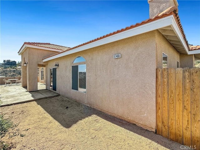 57466 Buena Suerte Rd, Yucca Valley, CA 92284 - view of side of home with stucco siding, a tile roof, and a patio