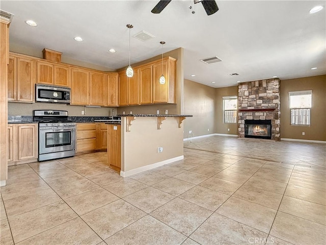 57466 Buena Suerte Rd, Yucca Valley, CA 92284 - kitchen featuring stainless steel appliances, plenty of natural light, a kitchen breakfast bar, a ceiling fan, and recessed lighting