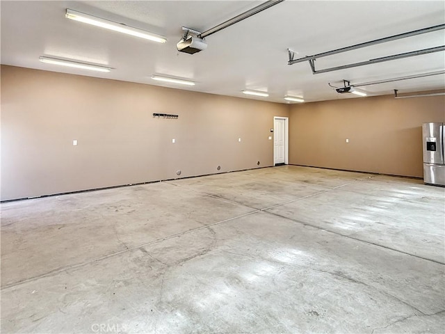 57466 Buena Suerte Rd, Yucca Valley, CA 92284 - garage with stainless steel fridge with ice dispenser and a garage door opener