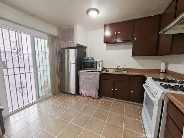 12836 12th St Unit 27, Chino, CA 91710 - kitchen featuring appliances with stainless steel finishes, under cabinet range hood, dark brown cabinets, and light tile patterned floors