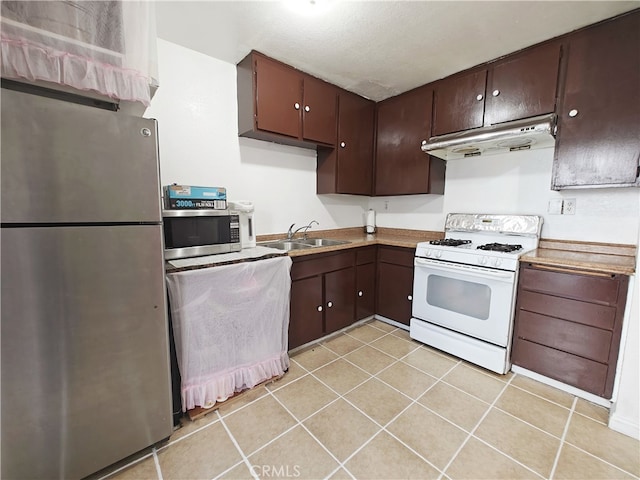 12836 12th St Unit 27, Chino, CA 91710 - kitchen with appliances with stainless steel finishes, under cabinet range hood, dark brown cabinetry, and light tile patterned floors