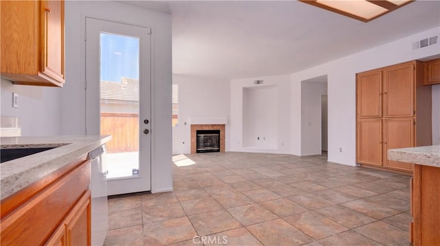 31995 Calle Ballentine, Temecula, CA 92592 - kitchen featuring light stone countertops, a tile fireplace, stainless steel dishwasher, and open floor plan