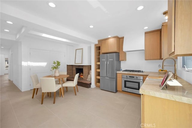 313 14th St, Seal Beach, CA 90740 - kitchen with appliances with stainless steel finishes, light countertops, recessed lighting, light tile patterned flooring, and a lit fireplace
