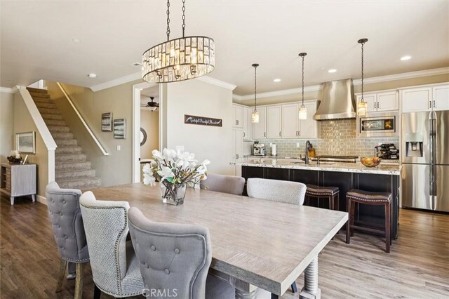 3032 Cortuna Dr, San Luis Obispo, CA 93401 - dining space with crown molding, stairs, wood finished floors, recessed lighting, and a chandelier