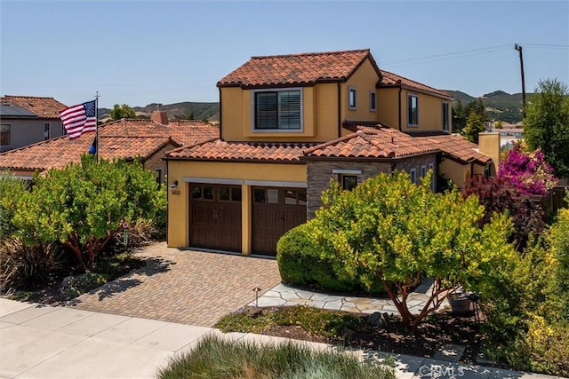 3032 Cortuna Dr, San Luis Obispo, CA 93401 - mediterranean / spanish-style home with a tiled roof, decorative driveway, stucco siding, a garage, and stone siding