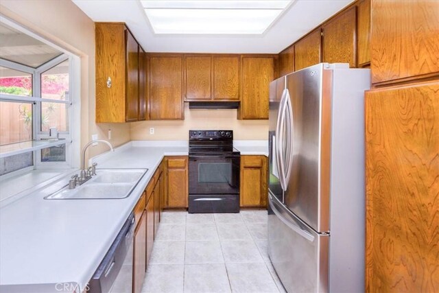 5709 Holly Ridge Dr, Camarillo, CA 93012 - kitchen with stainless steel appliances, brown cabinets, under cabinet range hood, light countertops, and light tile patterned floors