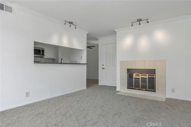 10655 Lemon Ave Unit 2809, Rancho Cucamonga, CA 91737 - unfurnished living room with ornamental molding, a tiled fireplace, carpet flooring, and ceiling fan