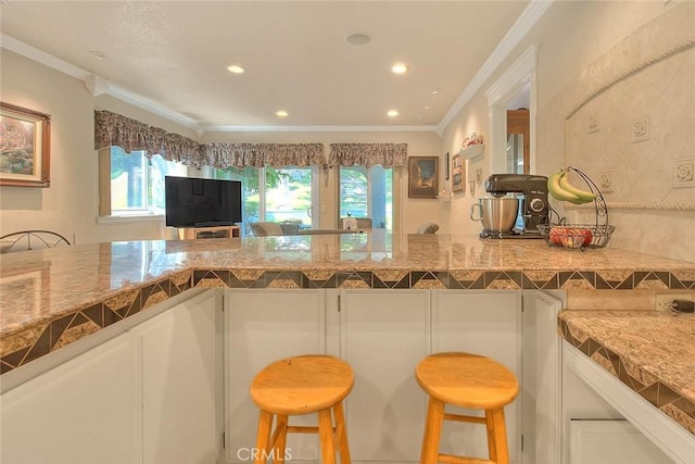 24 Edgebrook Dr, Phillips Ranch, CA 91766 - kitchen featuring crown molding, white cabinets, a breakfast bar area, recessed lighting, and backsplash