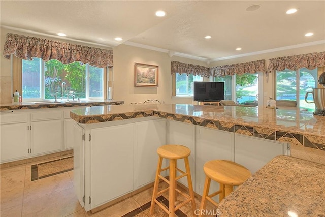24 Edgebrook Dr, Phillips Ranch, CA 91766 - kitchen featuring crown molding, recessed lighting, white cabinetry, a breakfast bar, and light tile patterned floors