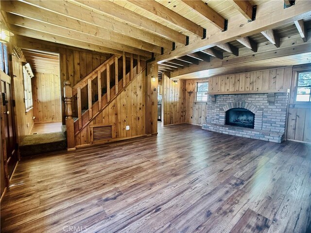 349 Golf Course Rd, Lake Arrowhead, CA 92352 - unfurnished living room with wood finished floors, wooden walls, stairs, a brick fireplace, and a wood ceiling with exposed beams