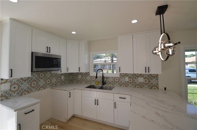 9422 Bartolo Ave, Pico Rivera, CA 90660 - kitchen with stainless steel microwave, light stone countertops, backsplash, white cabinetry, and recessed lighting