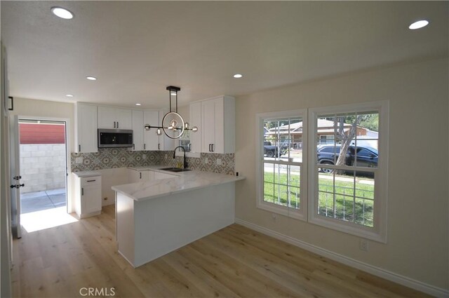 9422 Bartolo Ave, Pico Rivera, CA 90660 - kitchen featuring stainless steel microwave, light wood-style flooring, white cabinets, and recessed lighting