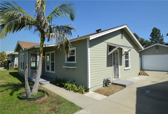 9422 Bartolo Ave, Pico Rivera, CA 90660 - view of side of property with an outbuilding, a detached garage, driveway, and a lawn