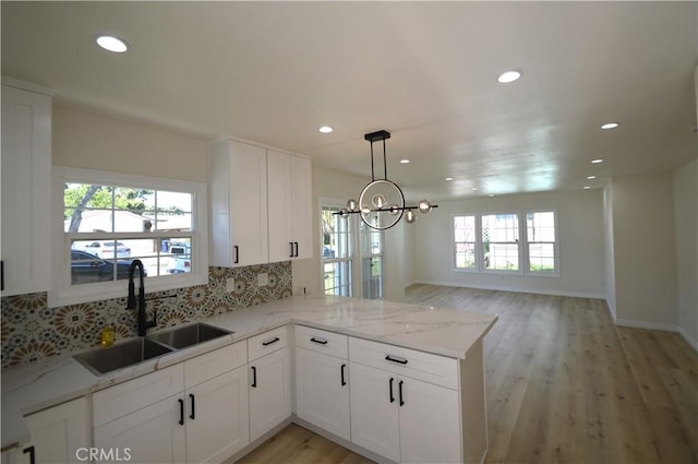 9422 Bartolo Ave, Pico Rivera, CA 90660 - kitchen featuring decorative backsplash, light wood-type flooring, white cabinetry, recessed lighting, and light stone countertops