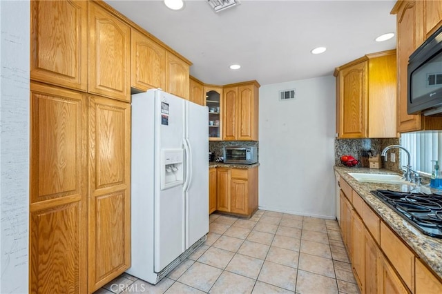 736 Highland Pl, San Dimas, CA 91773 - kitchen with white refrigerator with ice dispenser, gas cooktop, black microwave, tasteful backsplash, and light stone countertops