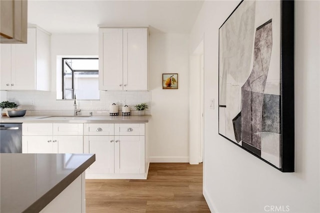 4709 W 149th St, Lawndale, CA 90260 - kitchen with dishwasher, backsplash, light wood finished floors, and white cabinetry
