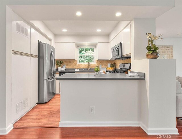 360 S Los Robles Ave Unit 10, Pasadena, CA 91101 - kitchen featuring stainless steel appliances, white cabinetry, a peninsula, light wood-style floors, and recessed lighting