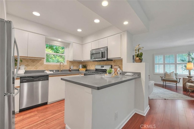360 S Los Robles Ave Unit 10, Pasadena, CA 91101 - kitchen with stainless steel appliances, a peninsula, white cabinetry, light wood finished floors, and recessed lighting