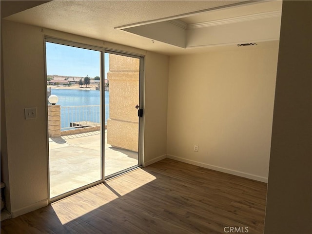 11496 Nautical Ln Unit 19, Helendale, CA 92342 - spare room featuring wood finished floors, ornamental molding, a tray ceiling, and a textured ceiling