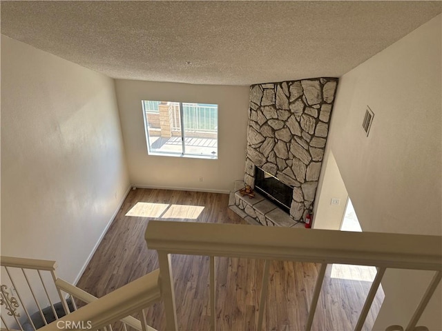 11496 Nautical Ln Unit 19, Helendale, CA 92342 - unfurnished living room with a textured ceiling, wood finished floors, and a stone fireplace