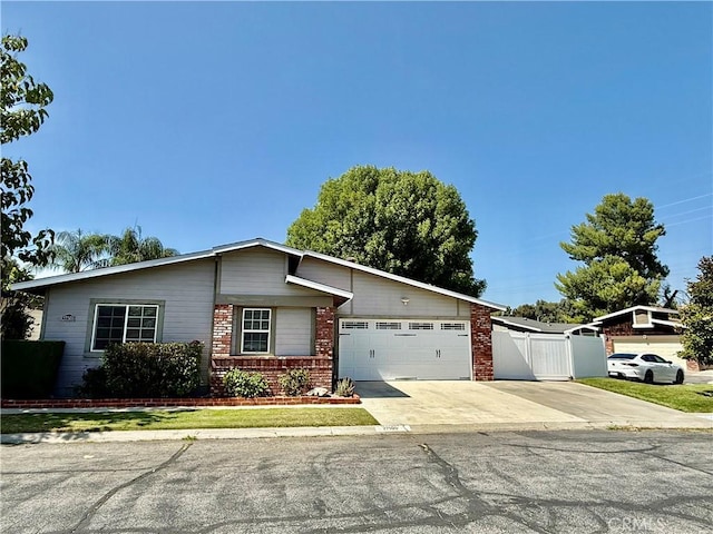 27505 Jasper Way, Castaic, CA 91384 - view of front of home featuring an attached garage, concrete driveway, brick siding, and a gate