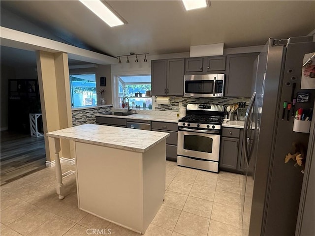 27505 Jasper Way, Castaic, CA 91384 - kitchen featuring stainless steel appliances, backsplash, a kitchen island, and light tile patterned floors