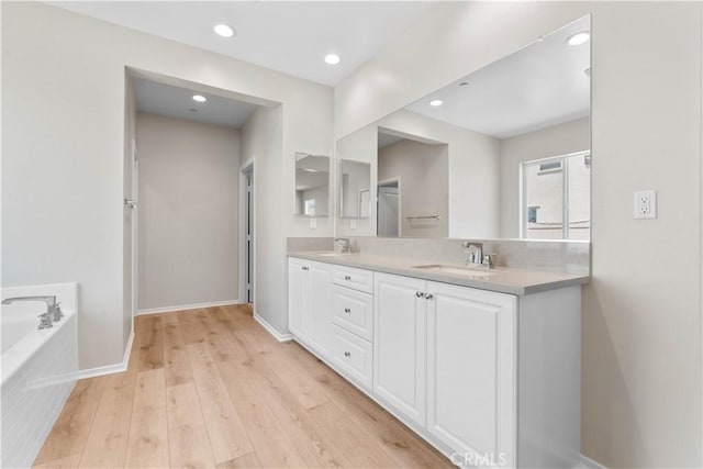 30071 Merrick Ln, Menifee, CA 92584 - bathroom with double vanity, a bath, wood finished floors, and recessed lighting
