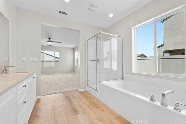 30071 Merrick Ln, Menifee, CA 92584 - bathroom with wood finished floors, a bath, a shower stall, vanity, and recessed lighting