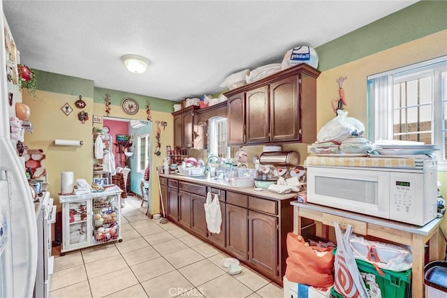 11847 Alabama St, Los Angeles, CA 90059 - kitchen with white microwave, light tile patterned floors, light countertops, and stainless steel range with gas cooktop