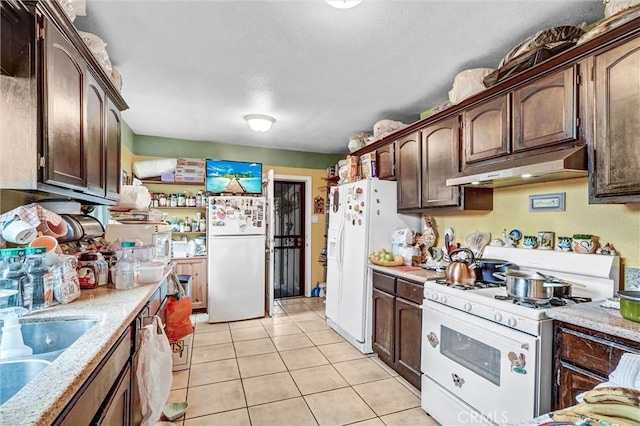 11847 Alabama St, Los Angeles, CA 90059 - kitchen with under cabinet range hood, white appliances, light tile patterned flooring, and dark brown cabinets