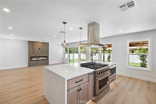 2405 Larchmont Ave, Santa Ana, CA 92706 - kitchen featuring high end stainless steel range, island range hood, light wood-type flooring, recessed lighting, and a fireplace