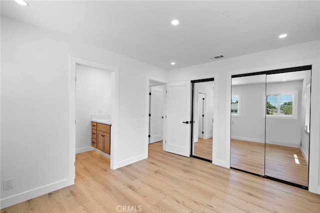 2405 Larchmont Ave, Santa Ana, CA 92706 - unfurnished bedroom with multiple closets, light wood-style floors, and recessed lighting