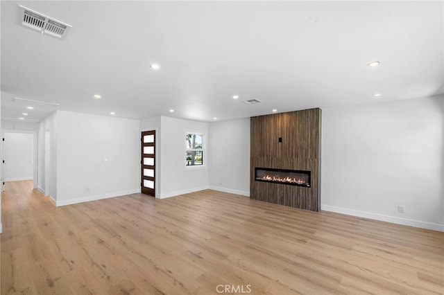 2405 Larchmont Ave, Santa Ana, CA 92706 - unfurnished living room with recessed lighting, light wood-style flooring, and a large fireplace