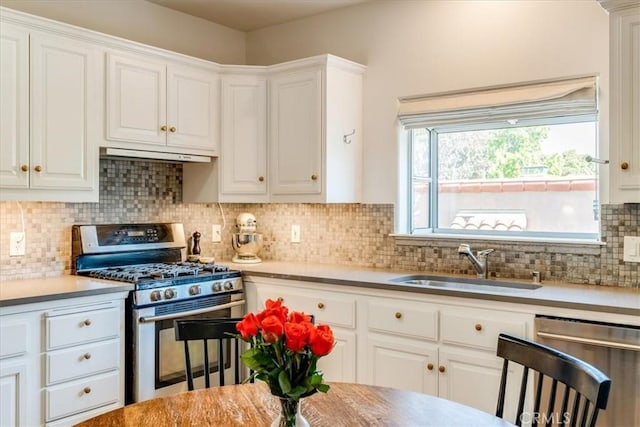 680 Howard St, San Luis Obispo, CA 93401 - kitchen with stainless steel appliances, white cabinets, under cabinet range hood, decorative backsplash, and light countertops