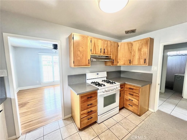 714 E Chapman Ave, Fullerton, CA 92831 - kitchen featuring gas range gas stove, under cabinet range hood, light tile patterned floors, and dark countertops