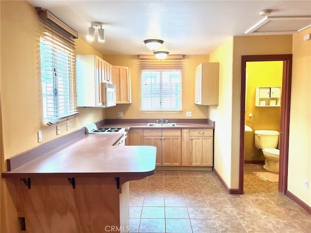 714 E Chapman Ave, Fullerton, CA 92831 - kitchen featuring white appliances, a peninsula, light tile patterned flooring, and a breakfast bar area