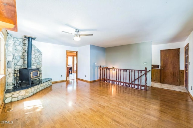 352 Cedarbrook Dr, Twin Peaks, CA 92391 - unfurnished living room with wood finished floors, a wood stove, and a ceiling fan