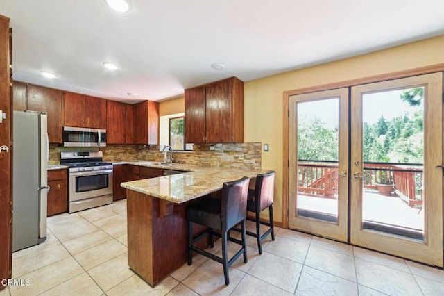 352 Cedarbrook Dr, Twin Peaks, CA 92391 - kitchen featuring appliances with stainless steel finishes, a peninsula, tasteful backsplash, french doors, and light stone counters