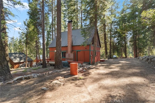 83634 Presidents Ln, Wilsona Gardens, CA 93633 - view of side of home with a chimney, a metal roof, a barn, and an outbuilding