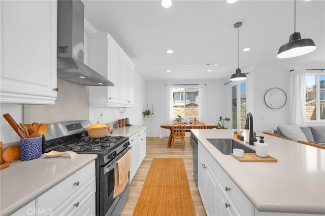 389 Allen Dr, Santa Paula, CA 93060 - kitchen with stainless steel gas range, wall chimney exhaust hood, light wood finished floors, plenty of natural light, and recessed lighting