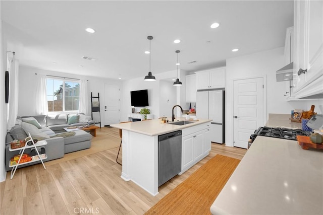 389 Allen Dr, Santa Paula, CA 93060 - kitchen with freestanding refrigerator, stainless steel dishwasher, open floor plan, white cabinetry, and exhaust hood