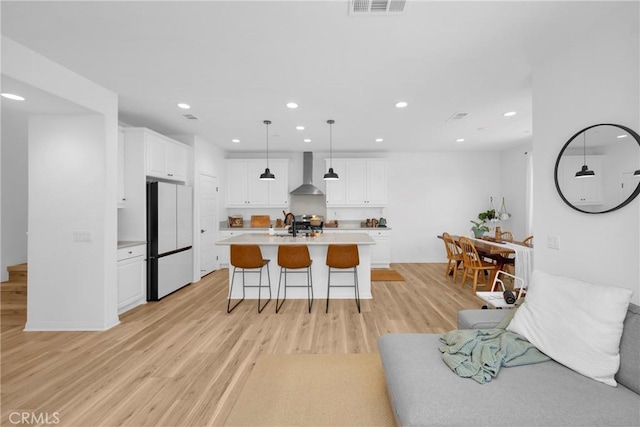 389 Allen Dr, Santa Paula, CA 93060 - kitchen featuring freestanding refrigerator, wall chimney exhaust hood, light wood-type flooring, light countertops, and recessed lighting