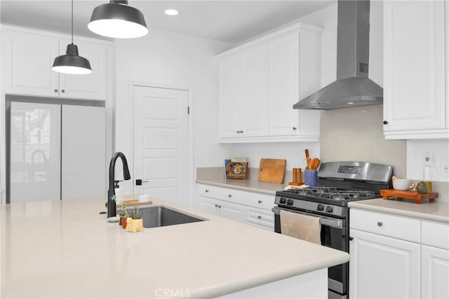 389 Allen Dr, Santa Paula, CA 93060 - kitchen with wall chimney exhaust hood, stainless steel gas stove, white cabinetry, light countertops, and recessed lighting