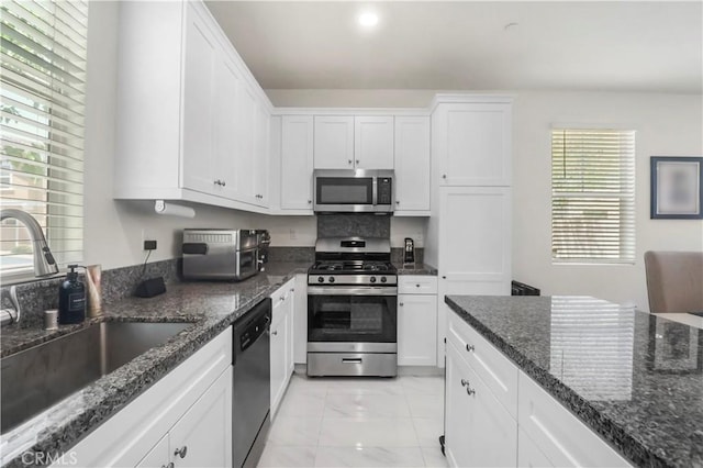 7911 Cold Creek St, Riverside, CA 92507 - kitchen with stainless steel appliances, light marble finish floors, white cabinets, dark stone counters, and recessed lighting