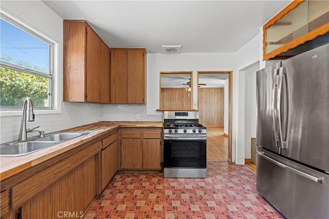 7737 Nestle Ave, Reseda, CA 91335 - kitchen featuring stainless steel appliances, brown cabinets, decorative backsplash, and butcher block counters