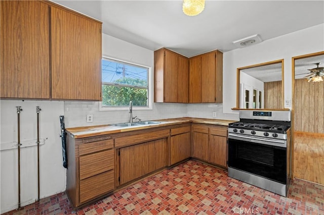 7737 Nestle Ave, Reseda, CA 91335 - kitchen featuring stainless steel range with gas cooktop, light countertops, backsplash, and brown cabinetry
