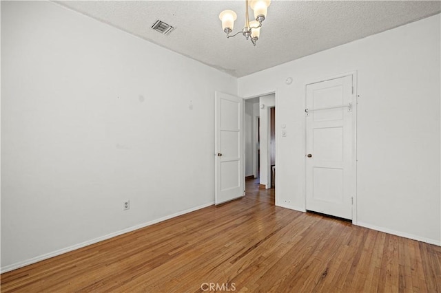 7737 Nestle Ave, Reseda, CA 91335 - empty room with a chandelier, light wood-style floors, and a textured ceiling
