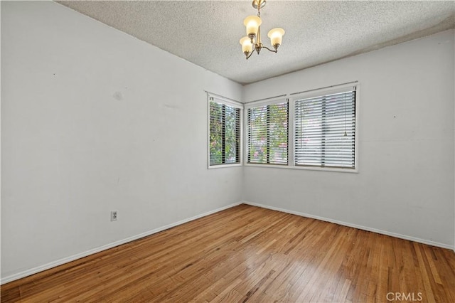 7737 Nestle Ave, Reseda, CA 91335 - spare room with a chandelier, hardwood / wood-style floors, and a textured ceiling