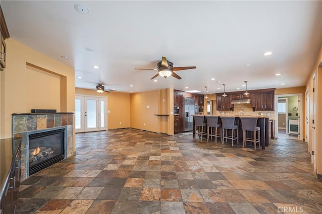 805 Ocean Ave Unit 6, Seal Beach, CA 90740 - kitchen with stone tile floors, a breakfast bar, light countertops, ceiling fan, and backsplash