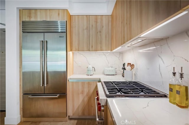 399 E Del Mar Blvd Unit 110, Pasadena, CA 91101 - kitchen with built in refrigerator, stove, backsplash, light brown cabinets, and light stone countertops